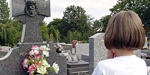 Enfant priant devant une tombe
